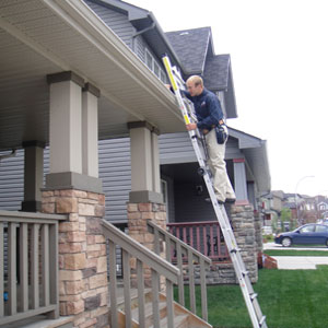 home inspector sw Calgary outside on a ladder