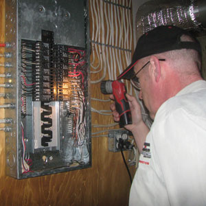 home inspector viewing inside electrical panel