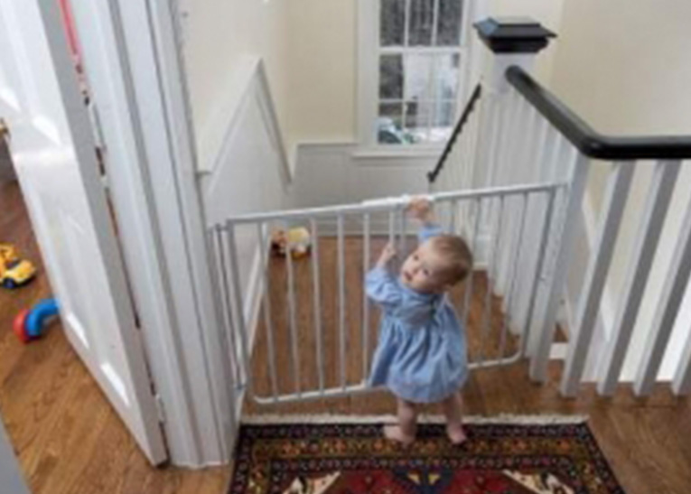 toddler in front of baby gate